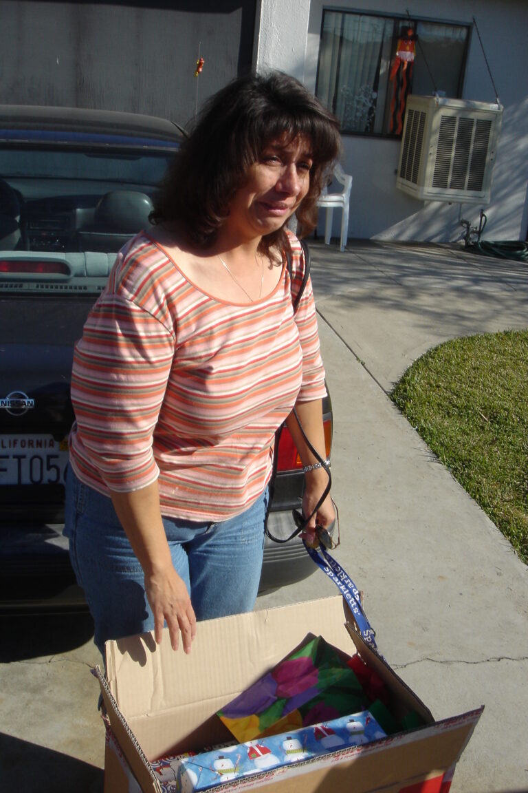 Woman receiving free Christmas gifts when in need cries.