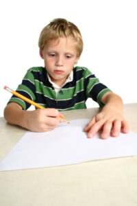 Young boy writes a letter to Santa seeking gifts for Christmas.