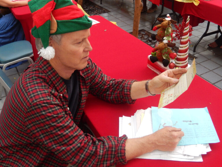 Volunteer Patrick Reynolds reads letters to Santa in Los Angeles.