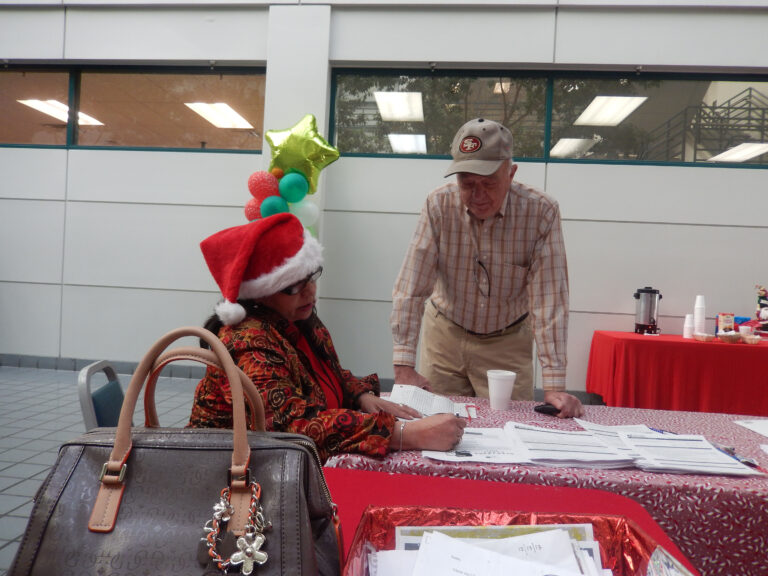 Man and woman volunteer to help sort LA letters to Santa.