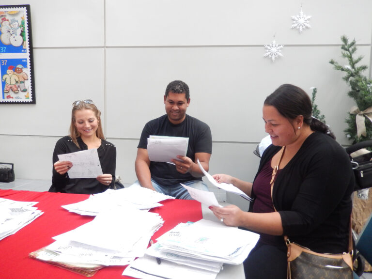 Volunteers for USPS Operation Santa read letters at the Los Angeles post office.